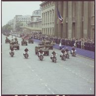 Défilé motorisé. Passage devant la tribune présidentielle et l'Ecole militaire du général de division Arnaud de Foïard, commandant les troupes et commandant la 11e division parachutiste (11e DP), à bord d'une automitrailleuse légère (AML) 60, précédé de motards de l'escadron motocycliste de la Garde républicaine lors de la cérémonie du 14 juillet 1977.