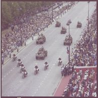 Vue aérienne du défilé motorisé. Passage du général de division Arnaud de Foïard, commandant les troupes et commandant la 11e division parachutiste (11e DP), à bord d'une automitrailleuse légère (AML) 60, précédé de motards de l'escadron motocycliste de la Garde républicaine lors de la cérémonie du 14 juillet 1977.