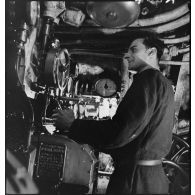 Sous-marinier de quart manoeuvrant, au cours d'un exercice, le tableau de commande des purges des ballasts du sous-marin des Forces navales françaises libres (FNFL) la Minerve.