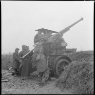 Des soldats approvisionnent un canon de 75 mm CA modèle 1917/34 sur remorque avec un obus modèle 28.