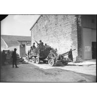 Un Citroën W 15 T tracte un canon CA de 25 mm modèle 1939 dans une rue de Cauroy.