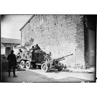 Un Citroën W 15 T tracte un canon CA de 25 mm modèle 1939 dans une rue de Cauroy.