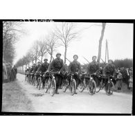 Photographié de face, un peloton de cyclistes polonais défile à pied bicyclette à la main.