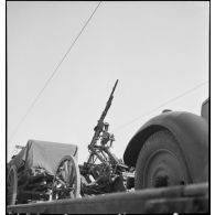 Une mitrailleuse Hotchkiss modèle 1914 sur affût hippotracté est photographiée sur un wagon ouvert.