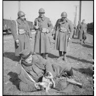 Photographie de groupe de soldats près d'une voie ferrée en gare de Trappes.