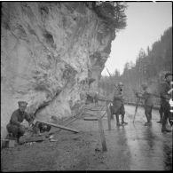 Une équipe de tournage SCA au travail sur une route de montagne des Alpes.