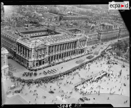 Vue aérienne des cérémonies du 14 juillet 1946 à Paris. Défilé de troupes à cheval sur la place de la Concorde.