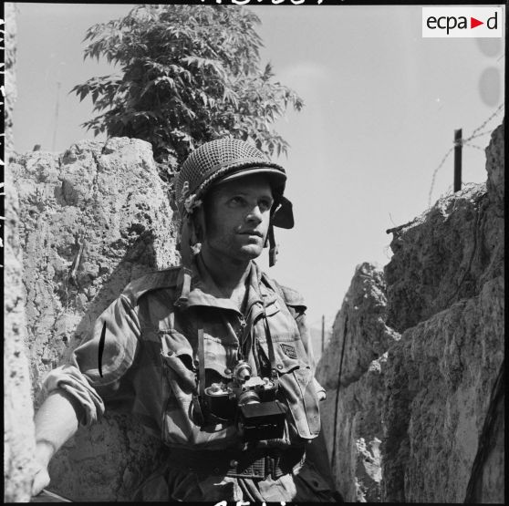 Le photographe du Service presse information (SPI) Jean Péraud, avec son appareil photographique Leica, dans une tranchée d'Isabelle à Diên Bien Phu.