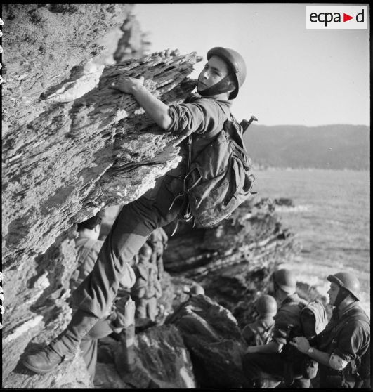 Des membres du groupe des commandos d'Afrique, devenu 5e bataillon de choc, escaladent les falaises du Cap Nègre (reconstitution).