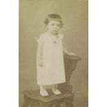 [Portrait d'un enfant en robe blanche debout sur une chaise].