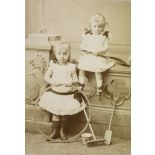 [Portrait de deux fillettes tenant un cerceau et une raquette].