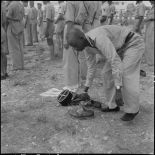Un officier africain musulman des troupes coloniales se déchausse pour se laver les mains et effectuer ses prières, avant l'embarquement pour le pèlerinage à la Mecque.