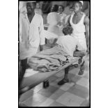 Un soldat, blessé dans la bataille de Diên Biên Phu, est transporté par des brancardiers de l'hôpital militaire Lanessan.