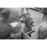 Dans un magasin d'approvisionnement, une bouteille de Champagne ou de mousseux (Sekt) est présentée à un soldat sur sa charrette.