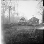 Un canon automoteur léger M8 HMC dépasse un char Sherman M4 endommagé vers Belfort.