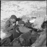 Un binôme FM du 86e BCA est posté dans un amas rocheux, les deux chasseurs sont photographiés de dos, ils servent un FM M24/29.