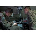 Un médecin des armées du SSA (Service de santé des armées) du Rôle 1 examine la bouche d'un artilleur français de la Task Force Wagram se plaignant de douleurs aux dents, en présence d'un aide soignant américain.