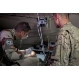 Un médecin des armées du SSA (Service de santé des armées) examine la bouche d'un artilleur français de la Task Force Wagram se plaignant de douleurs aux dents, en présence d'un aide soignant américain.