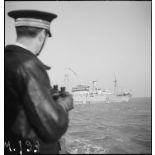 Le capitaine de frégate Maurice Guierre, commandant la police de la navigation et la direction du blocus à Dunkerque, observe à l'horizon le navire marchand norvégien Lenda.