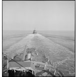 Un convoi de contre-torpilleurs d'une escadre navigue en ligne de file. Au premier plan, canons de 138 mm sur la plage avant.