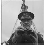 Portrait en contre-plongée du premier maître, commandant le chalutier de la marine marchande Roche noire, réquisitionné et armé par la Marine nationale.