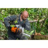L'aide-moniteur Felipe découpe à la tronçonneuse un arbre tombé sur le chemin d'accès aux pirogues au centre d'entraînement en forêt équatoriale (CEFE) à Régina, en Guyane française.