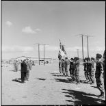 Le vice-amiral d'escadre Barjot salue le drapeau d'une unité parachutiste lors d'une cérémonie du 11 novembre au camp X (Chypre).