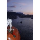 Un bateau-pompe salue l'arrivée du  ferry affrété Danielle Casanova à l'aube dans la rade de Toulon.