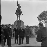 Robert Lacoste, ministre de l'Algérie, devant une statue à Alger.