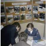 Une hôtesse accueille des étudiants sur un espace du stand de l'exposition Jeunesse 1976, dans l'ancienne gare de la Bastille à Paris.