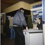 Un homme accueille un étudiant sur le stand de l'exposition Jeunesse 1976, dans l'ancienne gare de la Bastille à Paris.