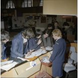 Une hôtesse accueille des étudiants sur un espace du stand de l'exposition Jeunesse 1976, dans l'ancienne gare de la Bastille.