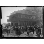 Port-Saïd, 7 h 20. La foule près d'un trou de bombe. A droite, le café près duquel la bombe est tombée (6 morts). [légende d'origine]