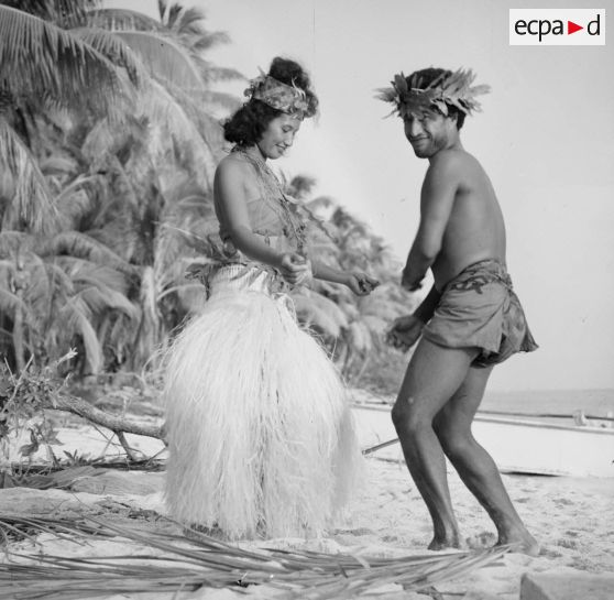 Un couple de danseurs, coiffés d'une couronne fleurie, fait une démonstration de danse du Tamoure sur une plage de l'atoll d'Hao.