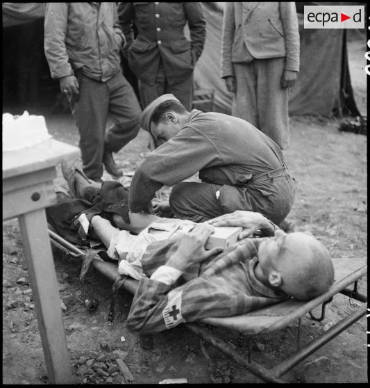 Du personnel médical fait des injections d'huile camphrée aux déportés malades du camp de Vaihingen récemment libéré. <br>