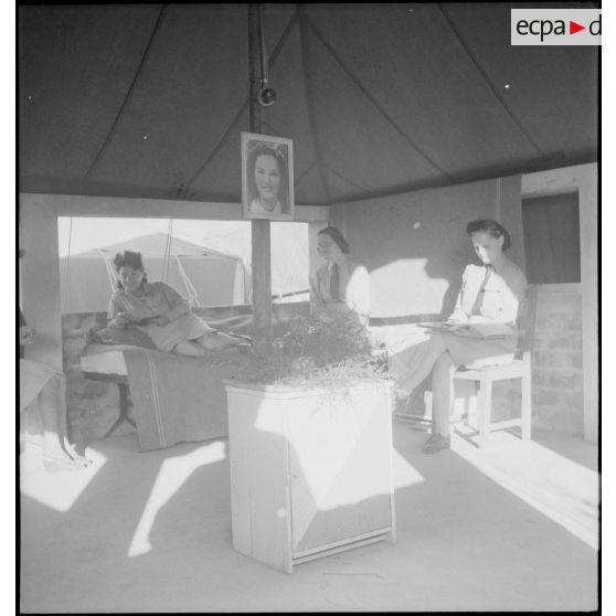Photographie de groupe de personnel féminin de l'armée de Terre sous une tente, dans un campement.