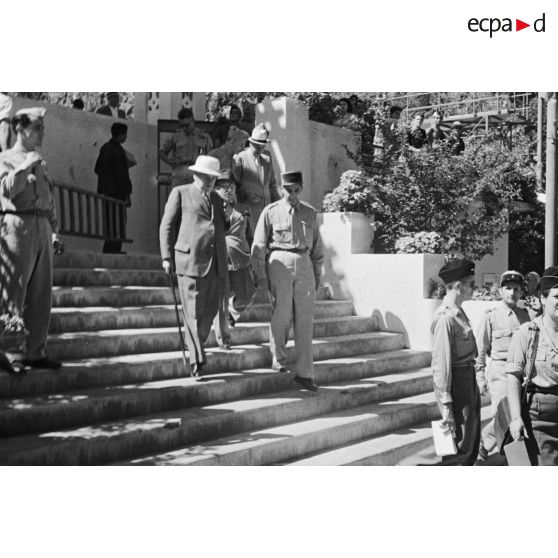 Des personnalités civiles et militaires decendent les escaliers de l'entrée de l'hôpital militaire Lavéran.