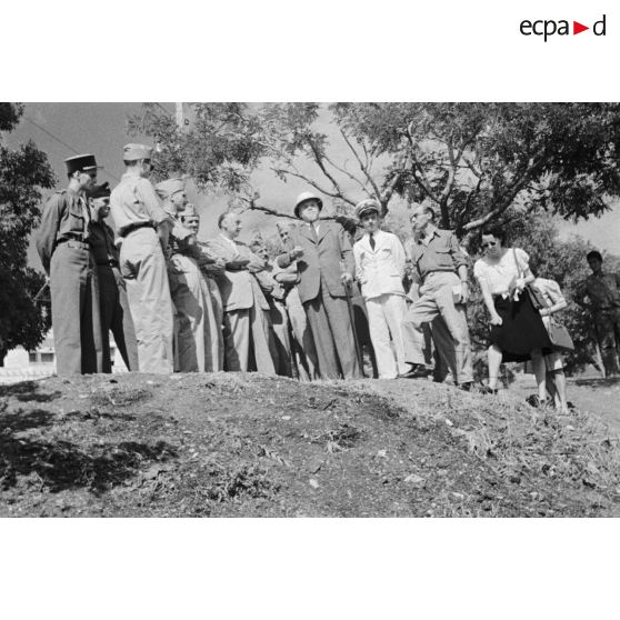 Vue en contre-plongée de personnalités civiles et militaires dans les jardins de l'hôpital Lavéran.