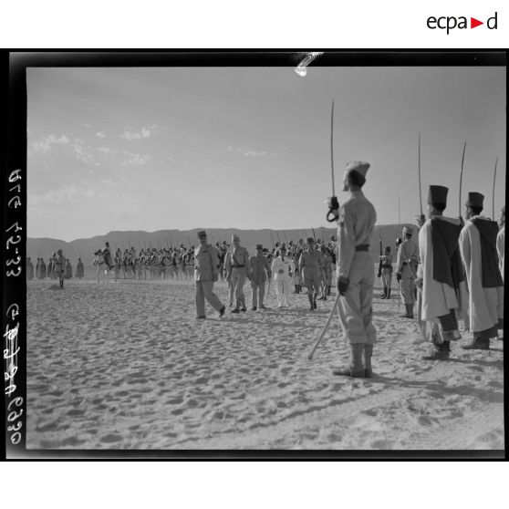 Le général de corps d'armée Henry Martin, suivi du général de division Jean Breuillac et d'autorités militaires, passe en revue les troupes de la 3e promotion des élèves officiers indigènes (EOI).