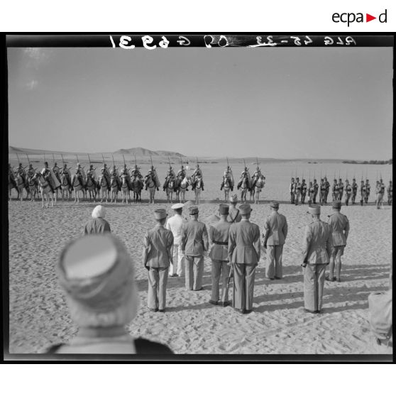 Le général de corps d'armée Henry Martin, suivi du général de division Jean Breuillac et d'autorités militaires, passe en revue les troupes de la 3e promotion des élèves officiers indigènes (EOI).