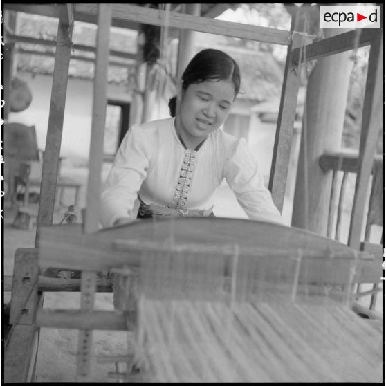 Utilisation d'un métier à tisser par une jeune femme de type Thaï blanc.