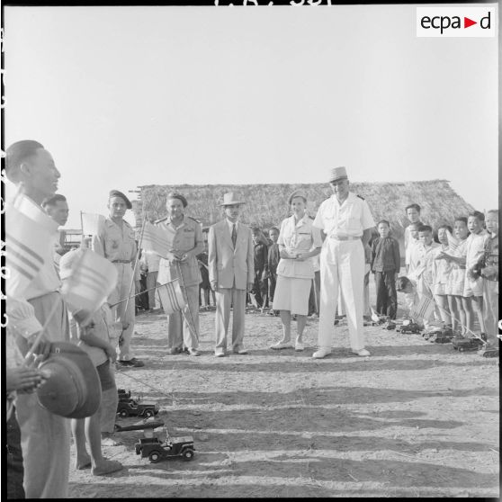 Le général de Linarès et une assistante sociale parmi un groupe d'enfants réfugiés Muong de Kobe qui chante en leur honneur après la distribution de cadeaux.