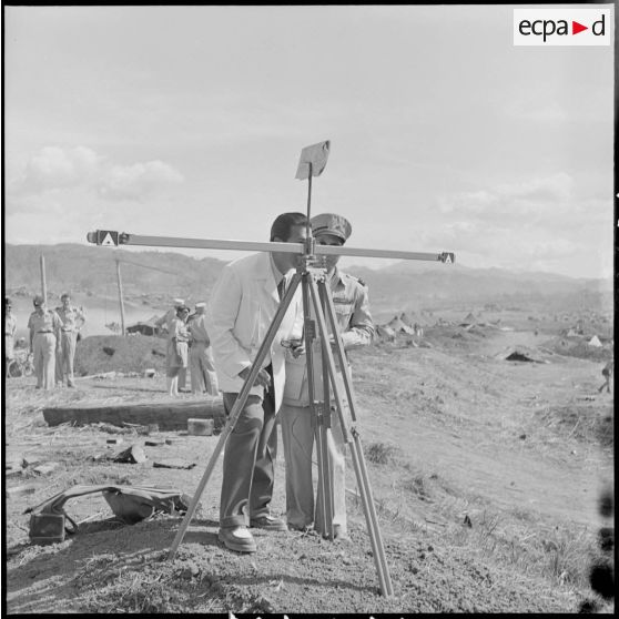 Aux abords du PC de Na San, Sa Majesté Bao Daï regarde dans un appareil de visée.