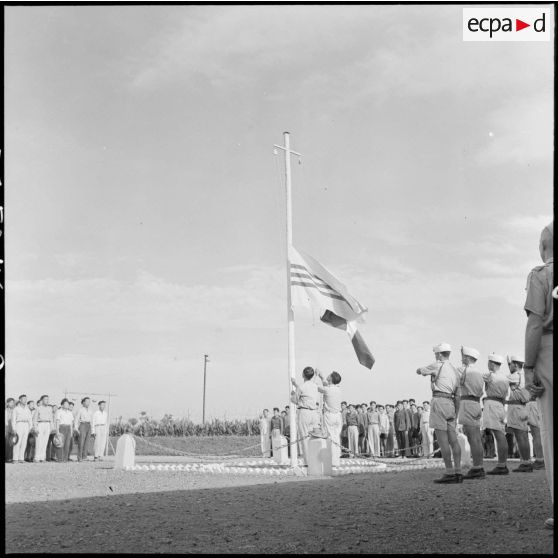 Lever des couleurs françaises et vietnamiennes au camp de Haiduong le jour de la libération d'un groupe de PIM.