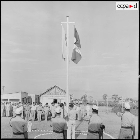 Lever des couleurs françaises et vietnamiennes au camp de Haiduong le jour de la libération d'un groupe de PIM.