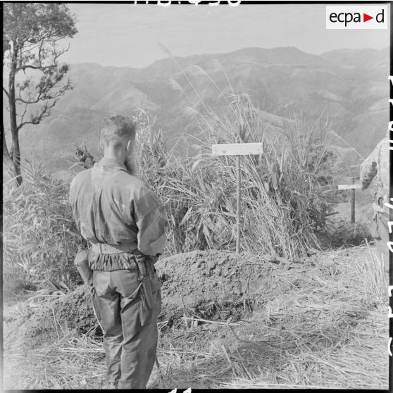 Le révérend-père Chevalier, aumônier du GAP 2 (groupement aéroporté n°2), se recueille sur la tombe des parachutistes vietnamiens.