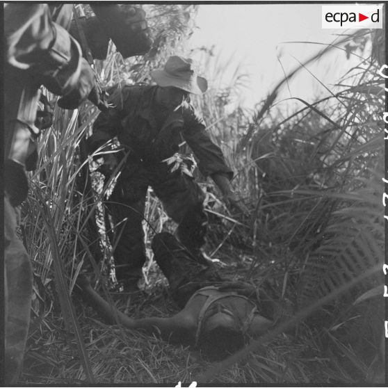 Un parachutiste du GAP 2 (groupement aéroporté n°2) prête secours à un blessé ami sur la piste.