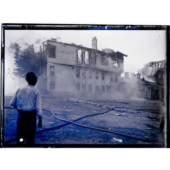 [Civil devant un bâtiment en feu.]