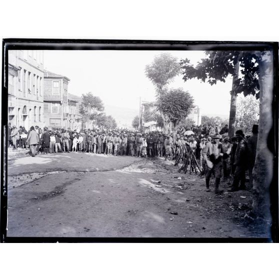 [Civils et soldats alignés dans une rue.]