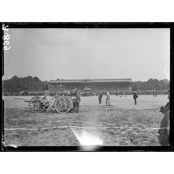 Hippodrome de Vincennes. Revue des sociétés de préparation militaire. Mise en position de tir d'un canon de 90. Au fond les tribunes. [légende d'origine]